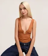 Body femenino de microfibra color terracota, con breteles anchos, escote en V profundo y detalle de adorno metálico rectangular en el centro del busto.