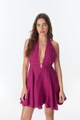 Vestido corto fucsia con escote halter y espalda descubierta.