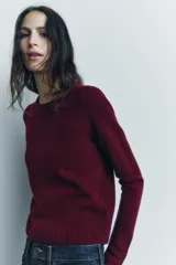 Jersey rojo de punto liso confeccionado en 100% lana. Tiene cuello redondo, manga larga y acabados en rib.