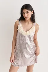 Vestido corto de fiesta, cubierto de lentejuelas plateadas, con escote en V y flecos de tul color crema.