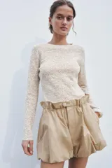 Top de punto color beige con textura, cuello redondo y manga larga.