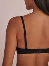Sostén tipo bralette negro de algodón, con escote en V y bordes festoneados. Presenta tirantes finos ajustables.