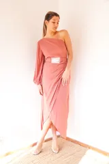 Vestido midi de crepé color salmón, con un hombro descubierto, manga larga abullonada y falda irregular con frunces. Incluye cinturón con hebilla plateada.