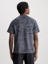 Remera gris con estampado abstracto en negro y logo de Calvin Klein en el pecho.