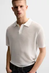 Polo color crudo de punto tejido con estructura calada, corte regular, cuello solapa con abertura frontal y manga corta.