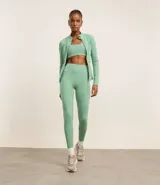 Campera deportiva color verde agua, confeccionada en microfibra, con cierre frontal, cuello alto, recortes en el frente y bolsillos laterales.
