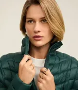 Campera puffer ultraligera color marrón, confeccionada en poliamida acolchada, con cuello alto y cierre por cremallera. Incluye bolsita con cordón.