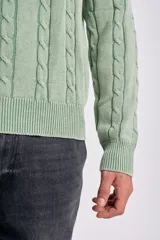 Sweater de tejido de punto color verde claro, con cuello redondo y diseño de ochos verticales en todo el cuerpo y mangas.