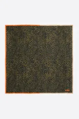 Pañuelo cuadrado de seda con estampado animal print en tonos verde oliva y negro, con borde naranja en dos de sus lados y borde beige en los dos restantes.