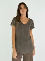 Remera color beige de corte recto, con cuello en V y mangas cortas con terminación desflecada.