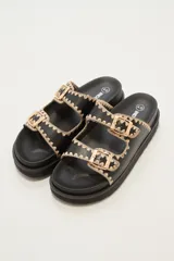 Sandalias negras con doble tira y hebillas doradas.