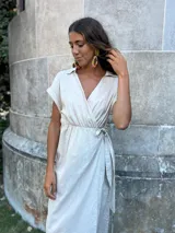 Vestido negro de lino con cuello y manga corta, corte a la cintura con lazo ajustable.