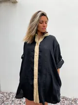 Camisa negra de lino con cuello clásico, cierre frontal con botones color beige y mangas 3/4 con trabillas.