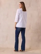 Blusa blanca de broderie con cuello a la base y escote en V. Apliques de brillos y piedras nacar en la parte delantera.