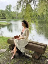 Túnica larga de gasa color beige claro, con mangas largas y cuello en V, con detalle de amarre frontal.