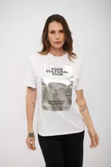 Remera blanca de manga corta con cuello redondo y un gran estampado frontal en tonos grises y negros que simula una fotografía con texto superpuesto que dice "YOUR CULTURAL ICON" y "DESIGN EVENT MELBOURNE".