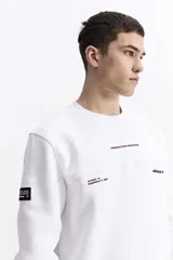 Buzo blanco de algodón con cuello redondo, puños y bolsillos laterales. Presenta un estampado en la espalda con cuatro imágenes de plantas en tonos sepia y texto.