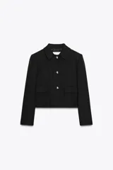 Chaqueta corta negra de tweed con cuello solapa, manga larga, bolsillos frontales con solapa y cierre frontal con botones plateados.