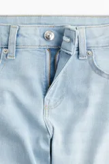 Pantalón de jean celeste de tiro bajo, corte ajustado en la cadera y acampanado desde la rodilla.