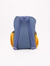 Mochila pequeña de colores, ideal para niños en edad preescolar. Cuerpo principal color crema, con borde superior y asa de agarre en azul oscuro. Bolsillo frontal grande en color verde oliva y bolsillos laterales en color mostaza/naranja.