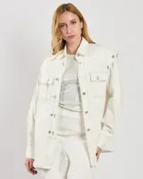 Chaqueta estilo camisa de algodón elástico color blanco, con mangas desmontables y botones. Costuras en contraste en toda la prenda y corte ligeramente oversize.