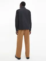 Sobrecamisa negra de sarga de algodón y nailon, corte boxy, cuello italiano, bolsillos con solapa en el pecho, billetera con botones, bajo recto, botones de gran tamaño e insignia con el logo de Calvin Klein en la manga.