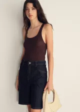 Short de jean azul oscuro, tiro alto, con cinco bolsillos, cierre frontal con cremallera y botón, trabillas para cinturón y corte recto.