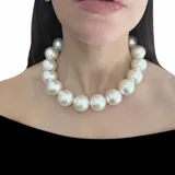 Collar corto de perlones de plástico color blanco, con cierre de mosquetón de acero y cadena para regular el largo.