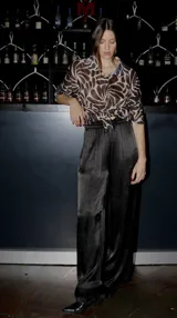 Pantalón negro de raso con bolsillos laterales, cintura elastizada con cordón ajustable y corte palazzo.