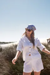 Conjunto blanco de camisa de manga 3/4 con botones y shorts.
