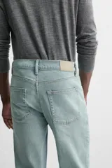 Pantalón de jean azul oscuro, corte slim fit, tiro medio, cinco bolsillos, tejido elástico y efecto lavado.