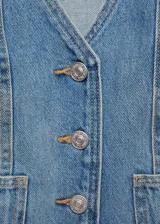 Chaleco de jean celeste con cuello en pico, dos bolsillos delanteros y cierre con botones.