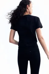 Remera negra de punto de algodón suave con cuello redondo ribeteado y bajo recto.