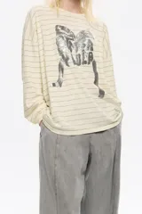 Remera de manga larga color crema con finas rayas horizontales grises. Presenta un estampado frontal grande en tonos grises y negros con tipografía y figura abstracta.