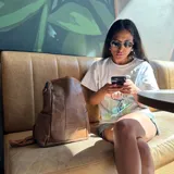 Mochila marrón de eco-cuero con cierre superior y correas ajustables.