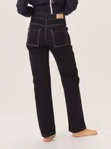 Jean recto de gabardina color marrón/camel, con pespuntes contrastantes en color negro. Presenta un detalle de atraque rojo en el bolsillo trasero.