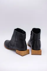 Botines de cuero negro con cierre lateral y taco bajo cuadrado de madera.