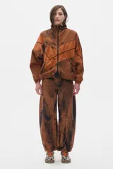 Campera estilo olímpica de jean color marrón con efecto lavado. Corte oversized, con elástico en la cintura, cuello alto y bolsillos al frente con cierre.