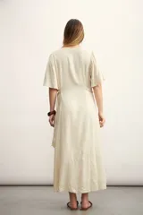 Vestido midi color beige con textura, escote en V, mangas cortas y abotonadura frontal.