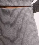 Pollera midi gris de rib acanalada con hilo metalizado, cintura elástica, abertura lateral y bajo ondulado.