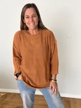 Suéter de punto grueso color caramelo, de corte oversize con cuello redondo y mangas largas caídas.