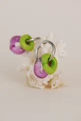 Par de aros colgantes con aro de acero quirúrgico y dijes circulares de cristal de Murano en color verde lima y lavanda.