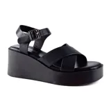 Sandalias negras con plataforma, tiras cruzadas sobre el empeine y pulsera con hebilla al tobillo.