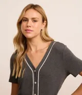 Conjunto de pijama americano gris oscuro, confeccionado en viscosa. Incluye una blusa de manga corta con cuello en V, abotonada al frente y detalle contrastante en blanco, y un pantalón capri con cintura elástica.