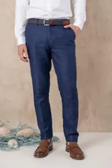 Pantalón de vestir para hombre, color azul oscuro, de corte slim fit y tiro medio. Presenta pliegues marcados y está confeccionado en tejido de lino.