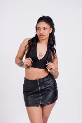 Minifalda negra de cuero sintético con cierre frontal y diseño acanalado horizontal.