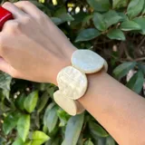 Pulsera elástica con cuentas grandes de resina color crema.