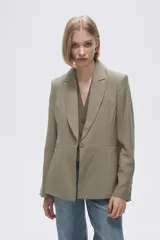 Blazer color crudo de rayon, entallado, con cuello solapa y cierre con un botón.