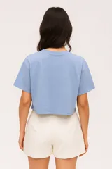 Remera cropped de algodón color crudo, con cuello redondo y estampado abstracto en el frente.