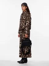 Camisa animal print con estampado de leopardo en tonos marrones y beige. Tiene cuello camisero, mangas largas con puños abotonados, cierre frontal con botones y dos bolsillos de parche en el pecho.